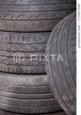 Automobile composition made up stack of tires and wheel with shiny disc in a car service before seasonal replacement or after breaking through. 113887990
