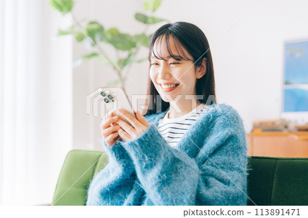 女人在沙發上使用智能手機 113891471