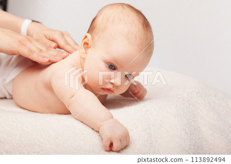 Little baby receiving chiropractic treatment of her back Little baby receiving chiropractic treatment of her back 113892494