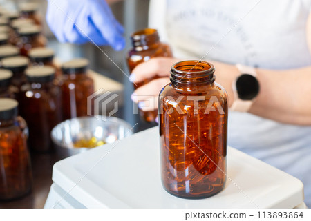 Close up one bottle of yellow Omega 3 vitamins and essential fish oils gel cap pills isolated on white background, low angle side view 113893864