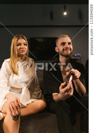 Guy presses buttons on joystick sitting with girlfriend 113894089
