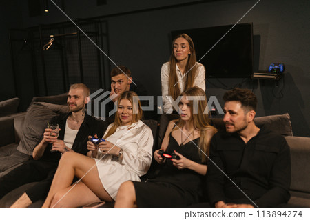 Females gamers with friends partake in animated console gameplay Females gamers with friends partake in animated console gameplay 113894274
