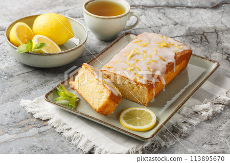Homemade glazed lemon pound cake closeup on the plate served with tea. Horizontal 113895670