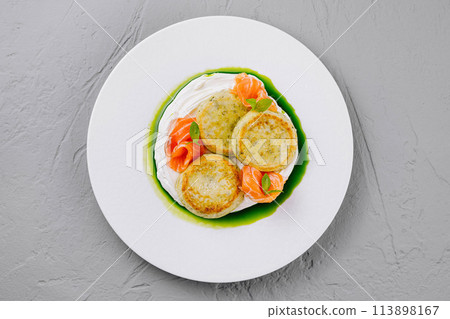 Gourmet fish cakes with herb sauce on white plate Gourmet fish cakes with herb sauce on white plate 113898167