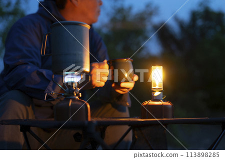 A man enjoying solo camping at dusk 113898285