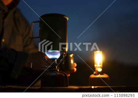 A man enjoying solo camping at dusk 113898293
