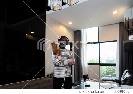 Young African American man for cleaning apartment, holding mop and other cleaning tools. Cheerful african american man housekeeping on weekend 113899002