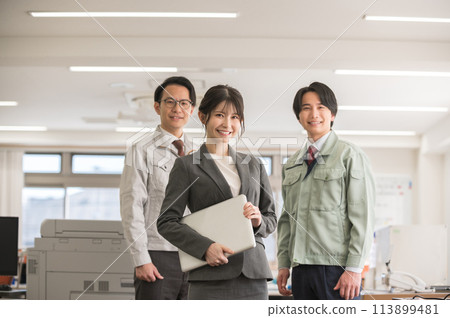 A woman in a suit with a laptop and a male engineer in work clothes 113899481