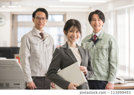 A woman in a suit with a laptop and a male engineer in work clothes 113899483