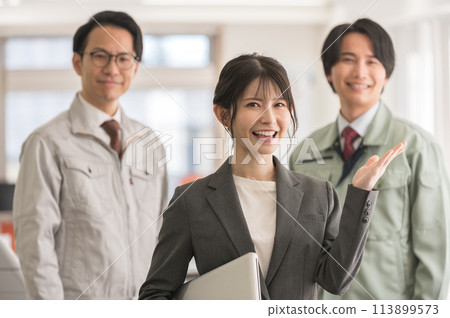 一名身穿西裝的女性和一名穿著工作服的男性工程師拿著筆記型電腦擺姿勢 113899573