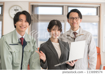 一名身穿西裝的女性和一名穿著工作服的男性工程師拿著筆記型電腦擺姿勢 113899574