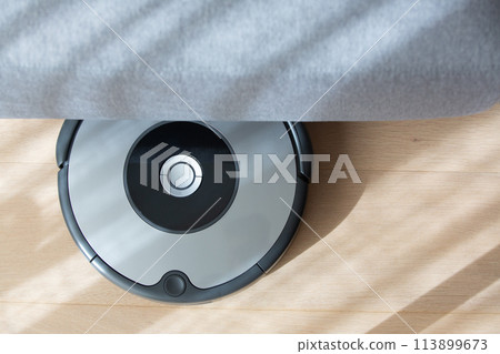 robot vacuum cleaner under a sofa. robot vacuum cleaner under a sofa. 113899673
