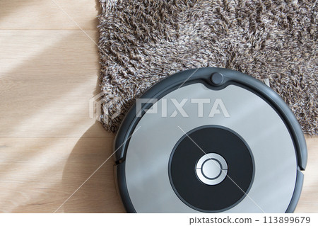 robot vacuum cleaner cleaning a carpet 113899679