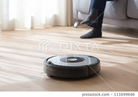 robot vacuum cleaner cleaning a living room 113899686