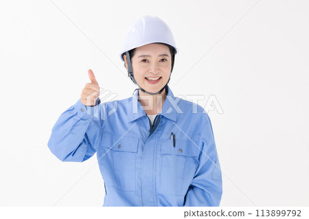 Woman in work clothes thumbs up 113899792