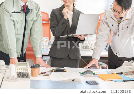 Three male and female engineers having a meeting in an office Three male and female engineers having a meeting in an office 113900128