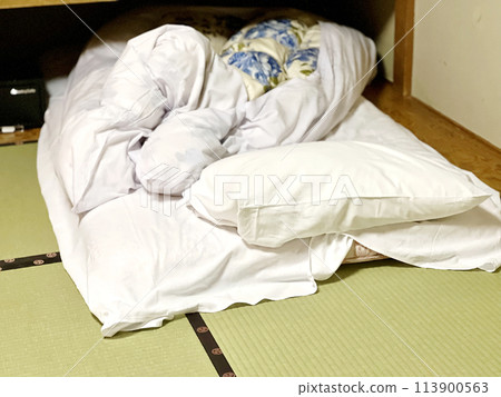 Disheveled futon in a hotel room 113900563