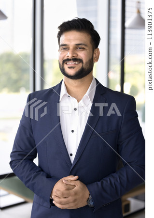Happy confident Indian company CEO man standing in office 113901375