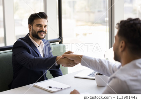 Positive young Indian business consultant and customer men shaking hands 113901442