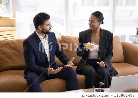 Two multiethnic business man and woman discussing work tasks Two multiethnic business man and woman discussing work tasks 113901492