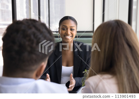Happy African American real estate consultant meeting with young couple Happy African American real estate consultant meeting with young couple 113901493