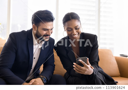 Cheerful multiethnic office friends watching funny online content 113901624
