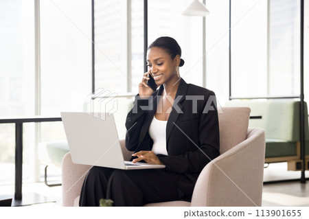 Positive African American business expert woman talking on mobile phone Positive African American business expert woman talking on mobile phone 113901655
