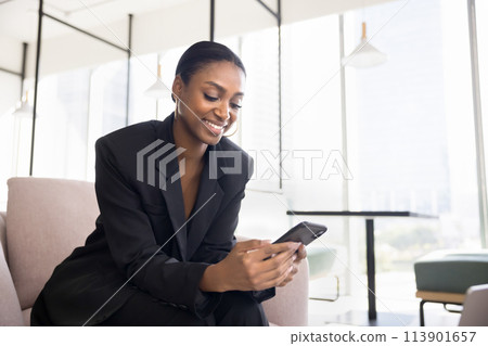 Positive beautiful Black business professional lady using application on cellphone Positive beautiful Black business professional lady using application on cellphone 113901657