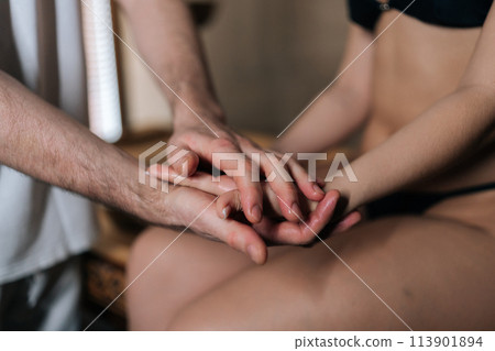 Closeup of unrecognizable relaxed woman getting professional massage of palm from male massage therapist. Masseur using acupressure techniques. Concept of body care and rehabilitation. 113901894