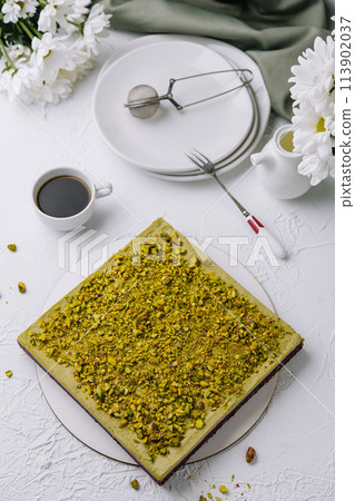 Pistachio cake on elegant white table setting 113902037