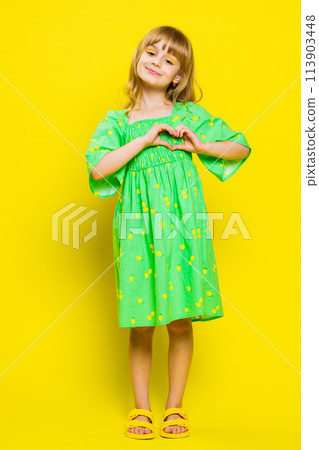 School child girl makes heart gesture demonstrates love sign expresses good feelings and sympathy 113903448