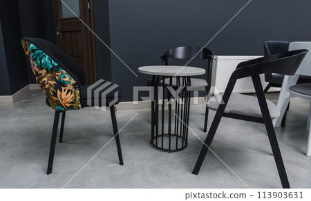 Gray wooden table combined with dark gray and black wooden chairs with soft fabric upholstery Gray wooden table combined with dark gray and black wooden chairs with soft fabric upholstery 113903631