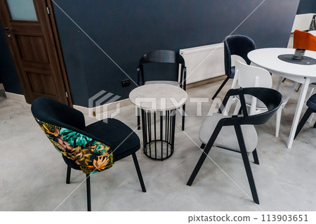 Gray wooden table combined with dark gray and black wooden chairs with soft fabric upholstery 113903651