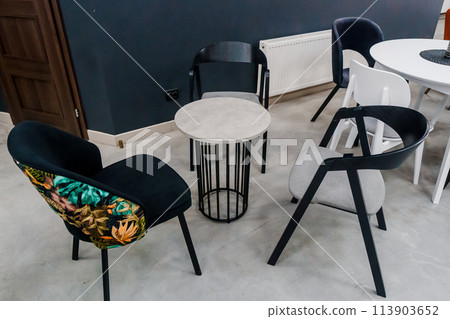 Gray wooden table combined with dark gray and black wooden chairs with soft fabric upholstery 113903652