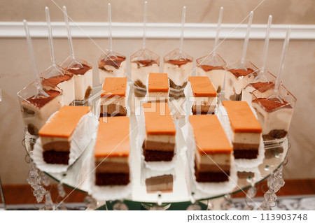 Sweet cakes at a wedding banquet. Catering, sweet festive buffet. Candy bar Sweet cakes at a wedding banquet. Catering, sweet festive buffet. Candy bar 113903748