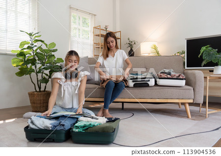 Friendship. Travel together. Two asian young woman friends packing for summer vocation. preparation planning concept 113904536