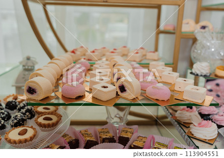 Sweet cakes at a wedding banquet. Catering, sweet festive buffet. Candy bar 113904551