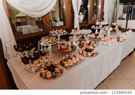 Sweet cakes at a wedding banquet. Catering, sweet festive buffet. Candy bar 113904584