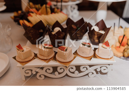 Sweet cakes at a wedding banquet. Catering, sweet festive buffet. Candy bar Sweet cakes at a wedding banquet. Catering, sweet festive buffet. Candy bar 113904585