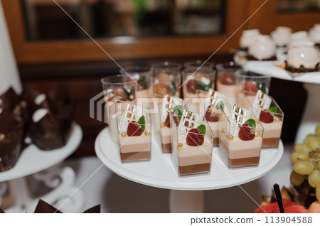 Sweet cakes at a wedding banquet. Catering, sweet festive buffet. Candy bar 113904588