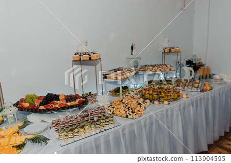 Sweet cakes at a wedding banquet. Catering, sweet festive buffet. Candy bar Sweet cakes at a wedding banquet. Catering, sweet festive buffet. Candy bar 113904595