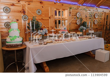 Sweet cakes at a wedding banquet. Catering, sweet festive buffet. Candy, chocolate bar. Mousse cakes Sweet cakes at a wedding banquet. Catering, sweet festive buffet. Candy, chocolate bar. Mousse cakes 113904599