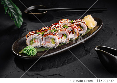Delicious sushi roll platter on dark slate background 113904832