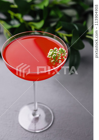 Elegant red cocktail with floral garnish Elegant red cocktail with floral garnish 113904908
