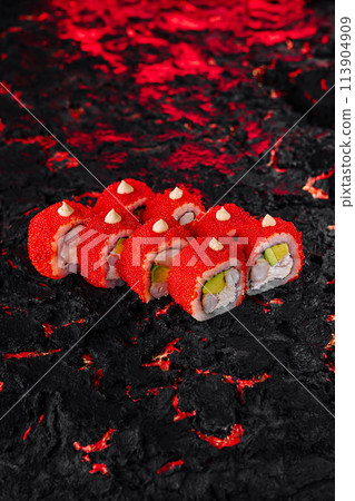 Vibrant red caviar sushi roll on textured black surface 113904909