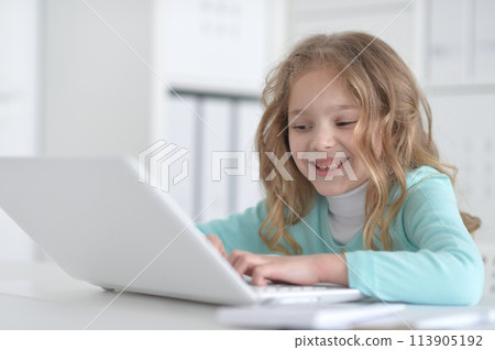 Cute and happy little girl children using laptop computer Cute and happy little girl children using laptop computer 113905192