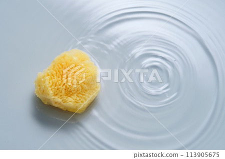 Natural sponge on a blue background with water. 113905675
