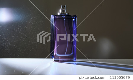 Perfume spray in a violet bottle on a dark background. Perfume spray in a violet bottle on a dark background. 113905679