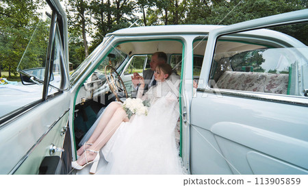 Bride and groom enjoying each other in a retro car. Bride and groom enjoying each other in a retro car. 113905859