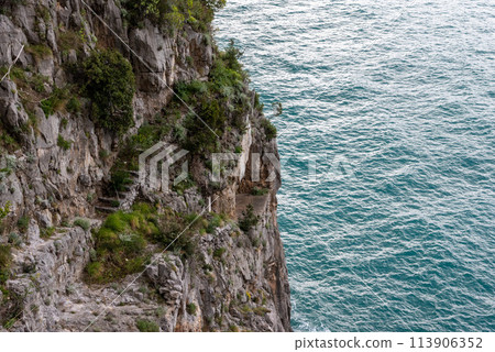 The old dangerous coastal passage at the cliffs of the Amalfi coast, Italy 113906352